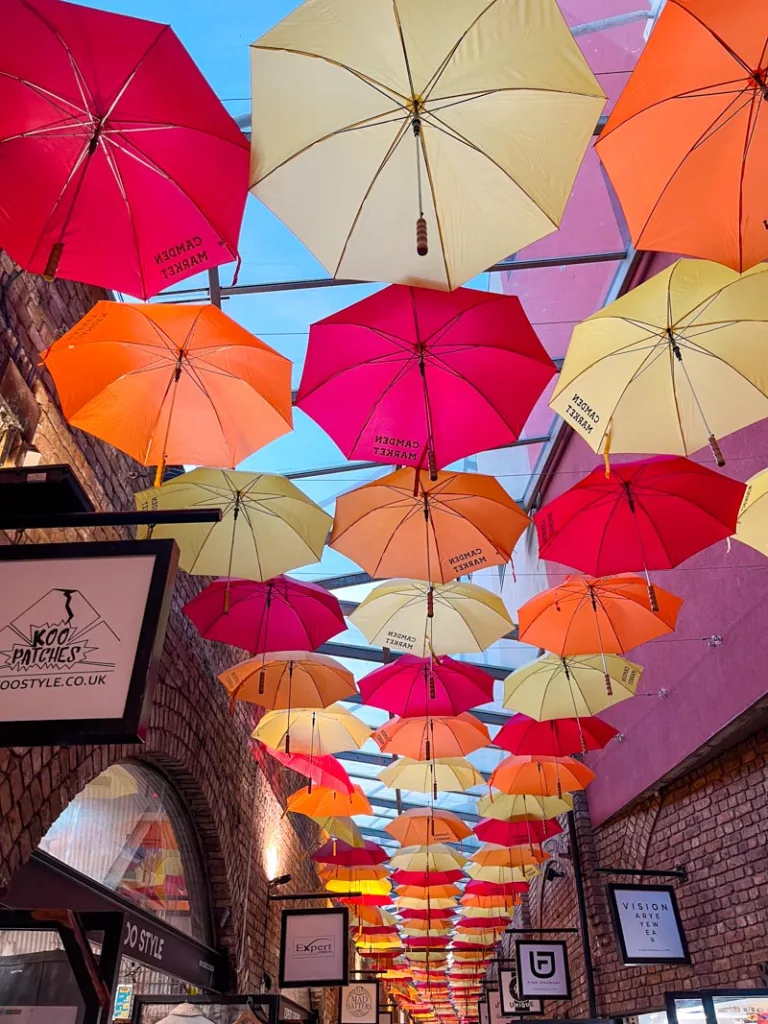 colorful umbrellas covering an alley at camden market in london