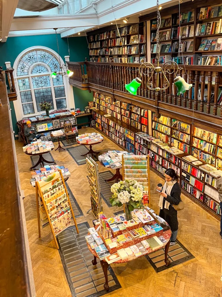 view from the second floor, looking down at the stacks of books in daunt bookshop in london
