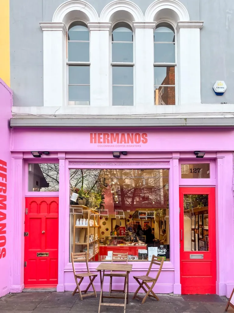 bright pink walls with red doors at hermanos colombian coffee shop in notting hill, london