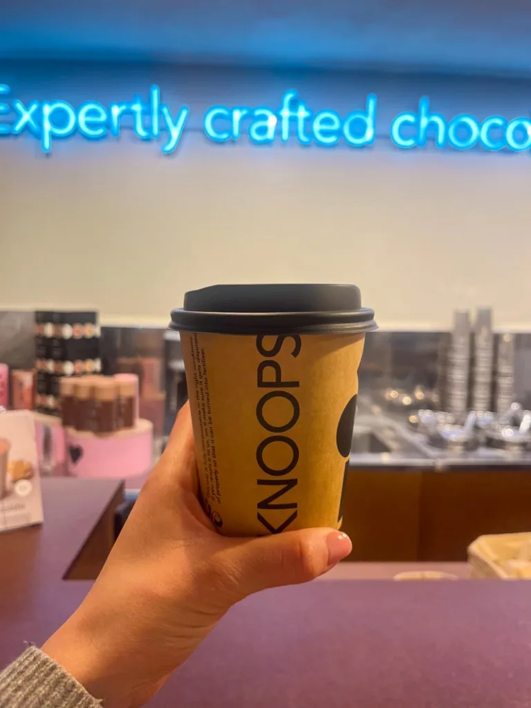 hand holding a take away cup of knoops hot chocolate in london