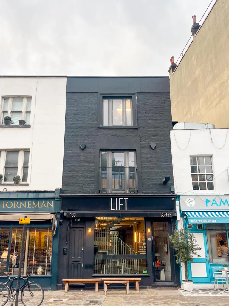 minimalist black brick facade of lift coffee shop in notting hill london