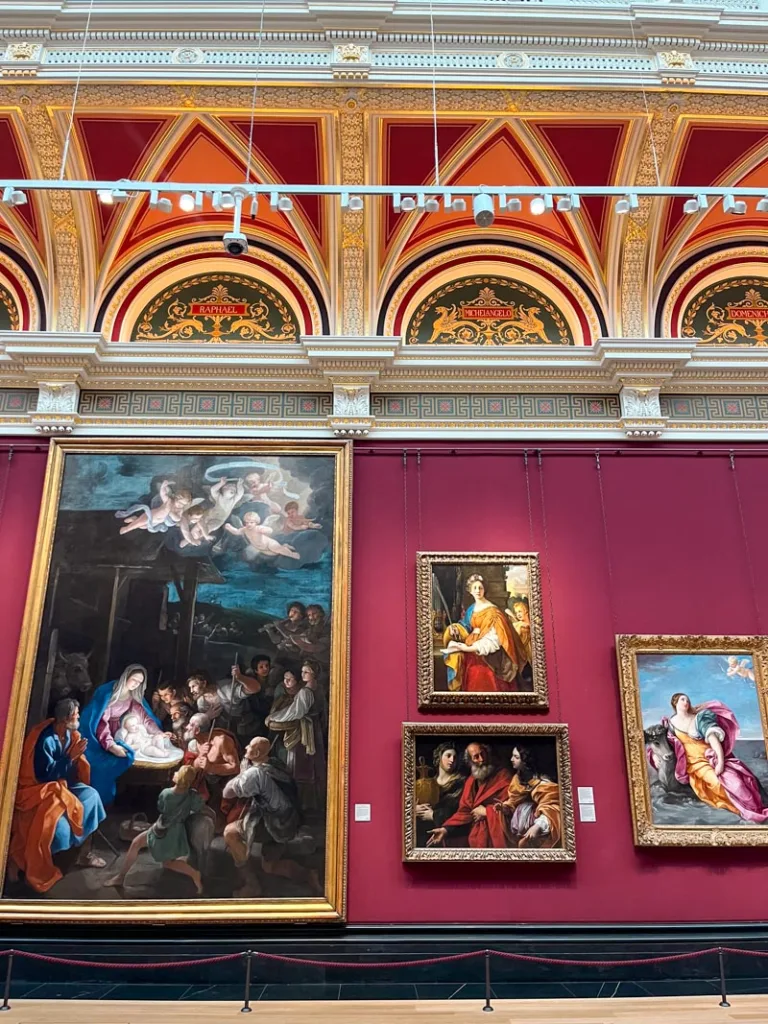 paintings on a burgundy wall at the natioonal gallery, london