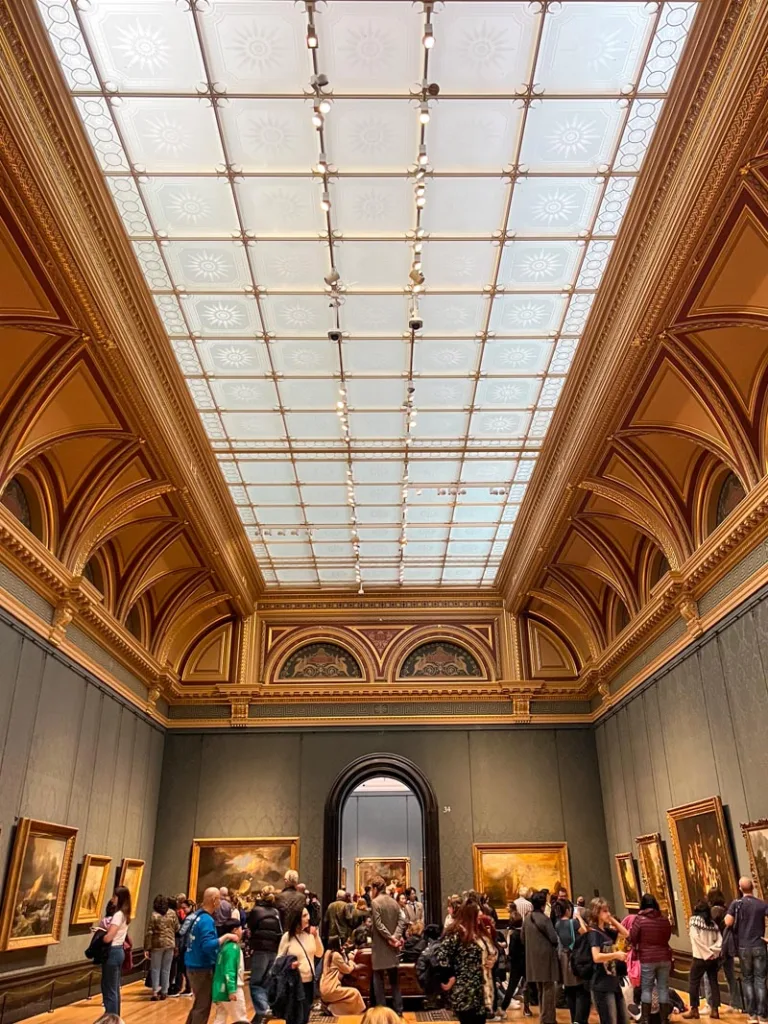 high-ceiling hall with paintings hanging on the walls at the national gallery in london
