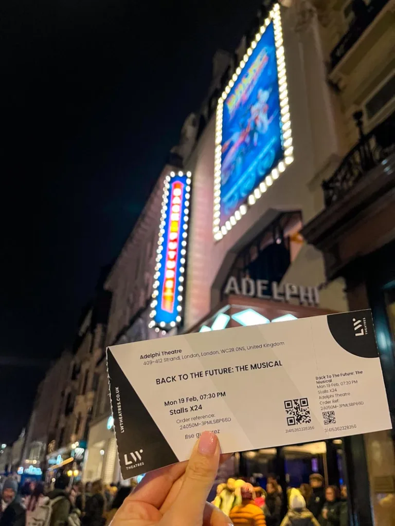 hand holding a ticket to back to the future outside the theatre in the west end, london