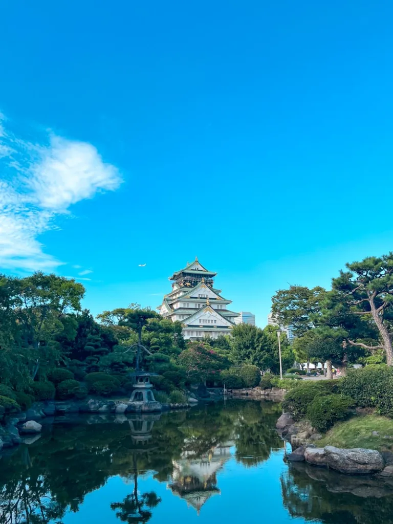 lake, trees and osaka castle at the back