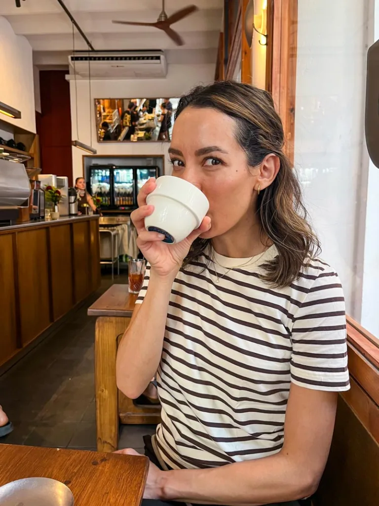 woman sipping on a white mug at sip coffee roasters in barcelona
