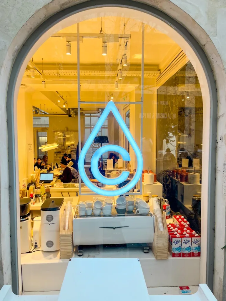 window looking into the coffee shop with the certified cafe logo in paris