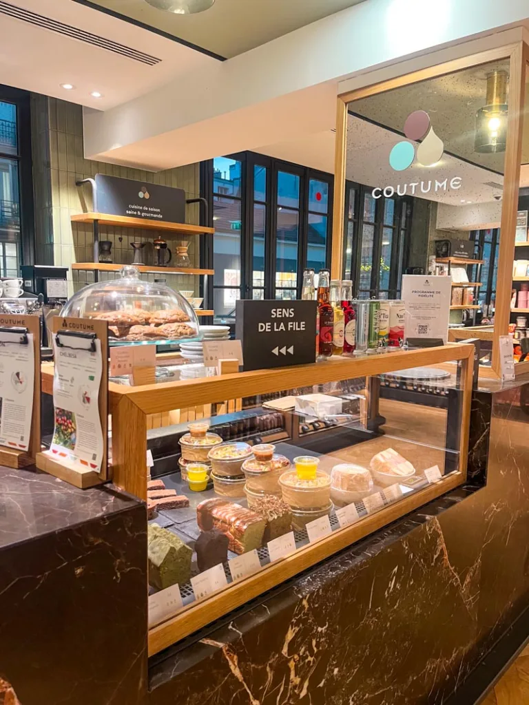marble bar with a pastry display at coutume specialty coffee shop in paris