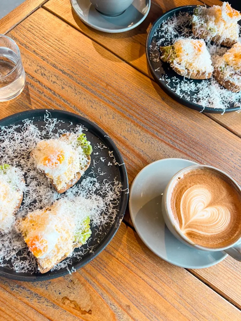 two coffee cups and two plates of cheese covered avocado toast with boiled eggs at coffee camp in hakone