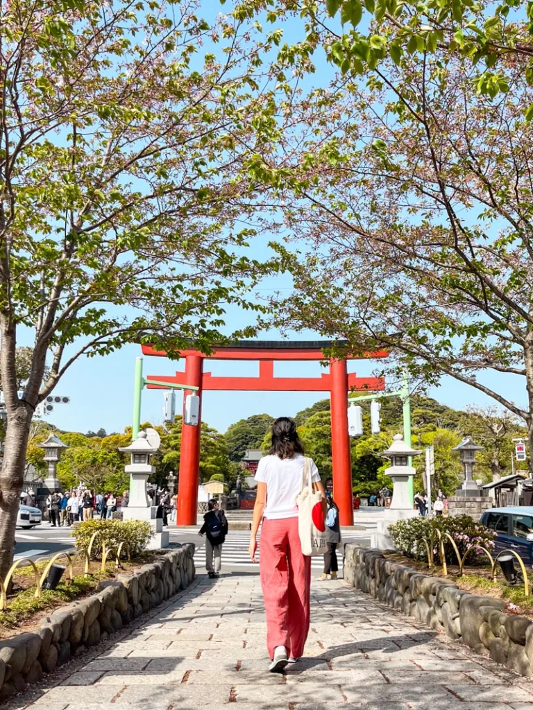 woman in front of a torii gate in Kamakura, one of the best places to visit in Japan for first timers