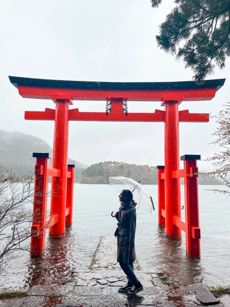 woman standing in front of the massive torii gate at hakone shrine