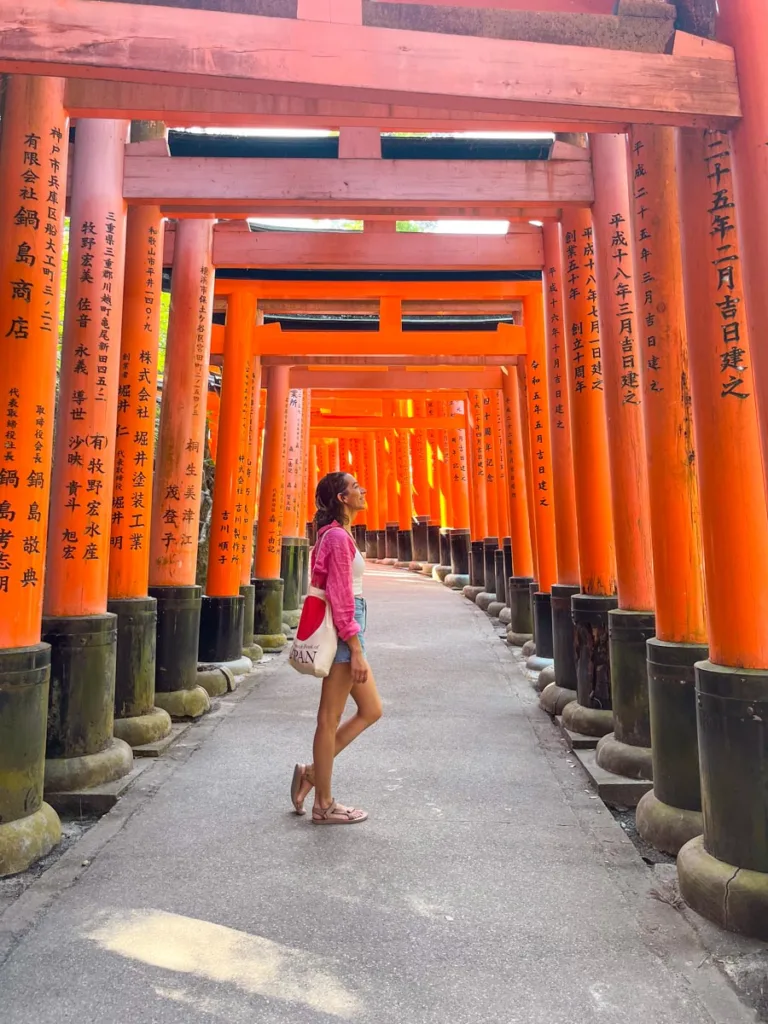 Woman standing under a Torii Gate tunnel in Kyoto