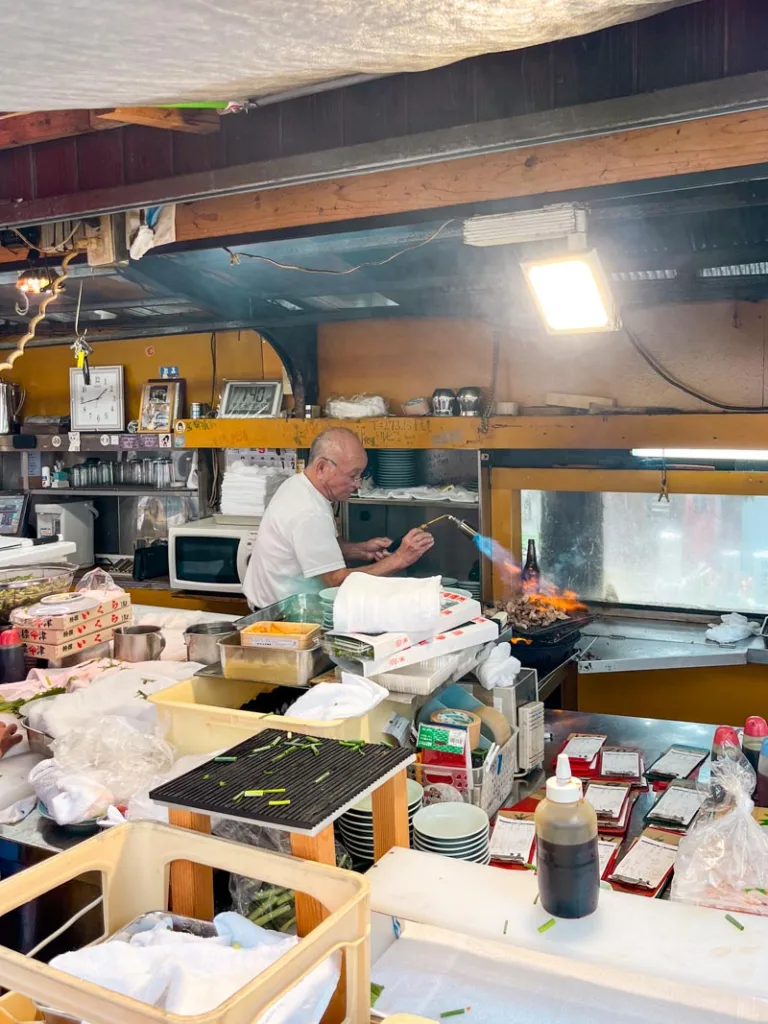 Toyo, a famous japanese chef flame throwing tuna cheeks with a flame thrower in Osaka