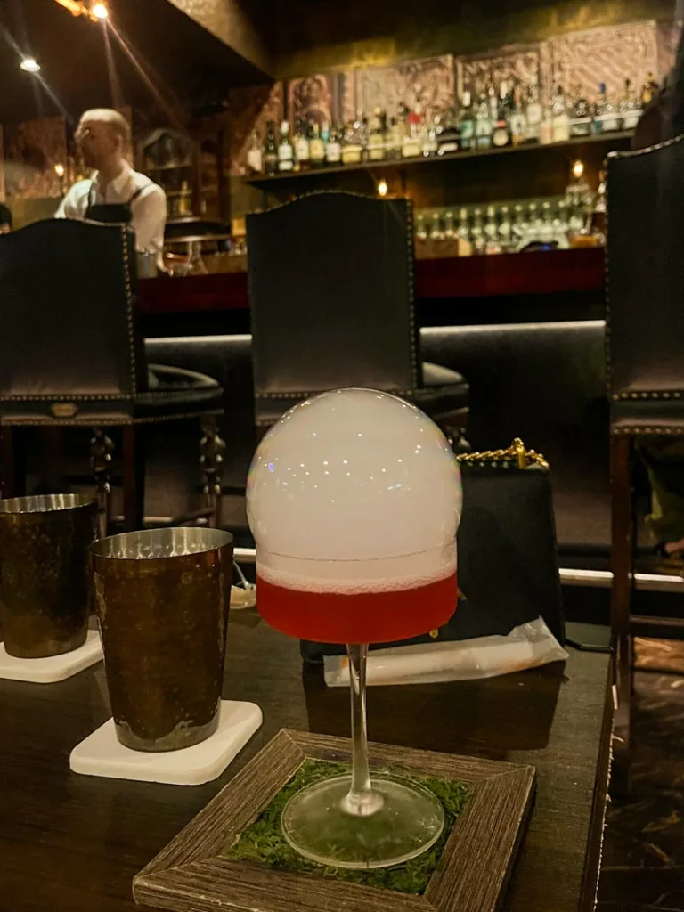 A cocktail with a bubble with smoke on top at Cocktail Library Bar in Osaka
