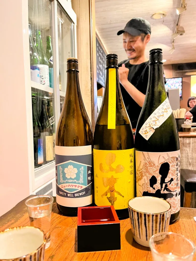 Three sake bottles on a table at Sake Ichiro, a cool bar in Osaka