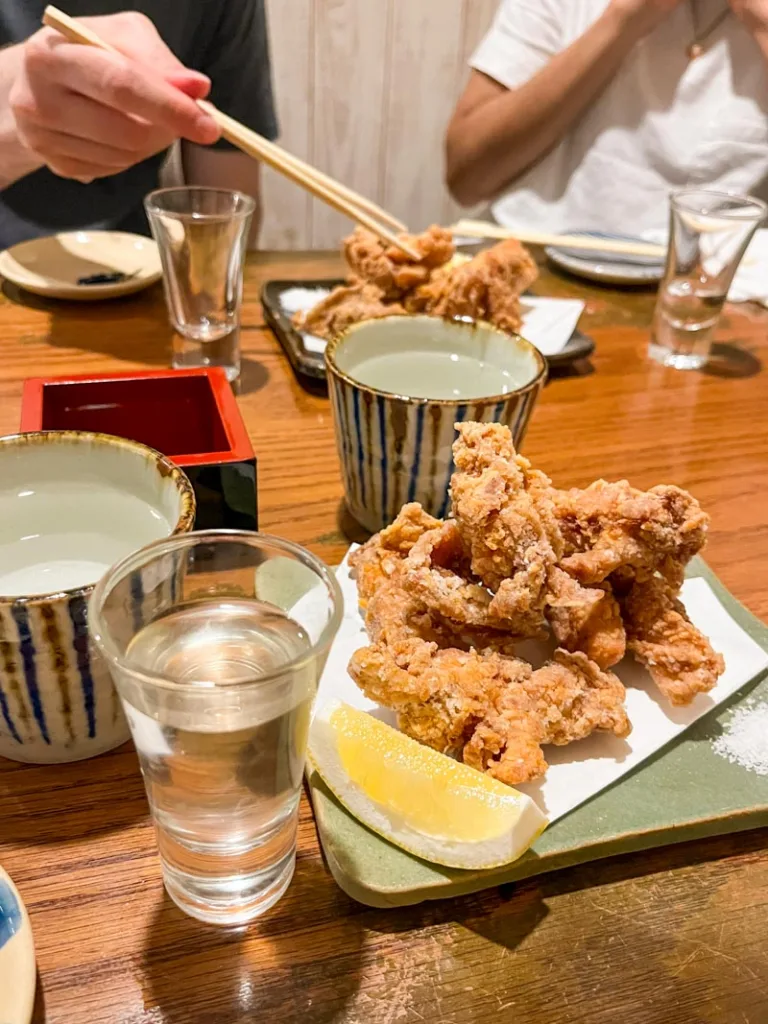 Two plates of karage and cups of sake at Sake Ichiro, a cool bar in Osaka