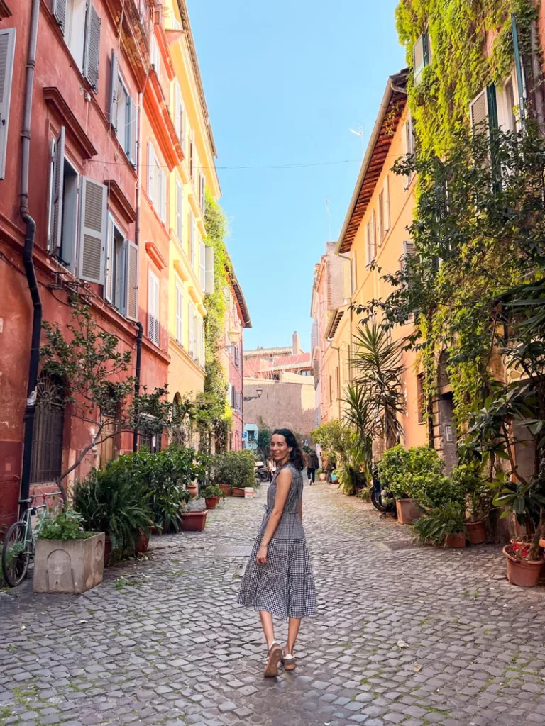 Woman standing in the middle of a colorful Trastevere street in Rome