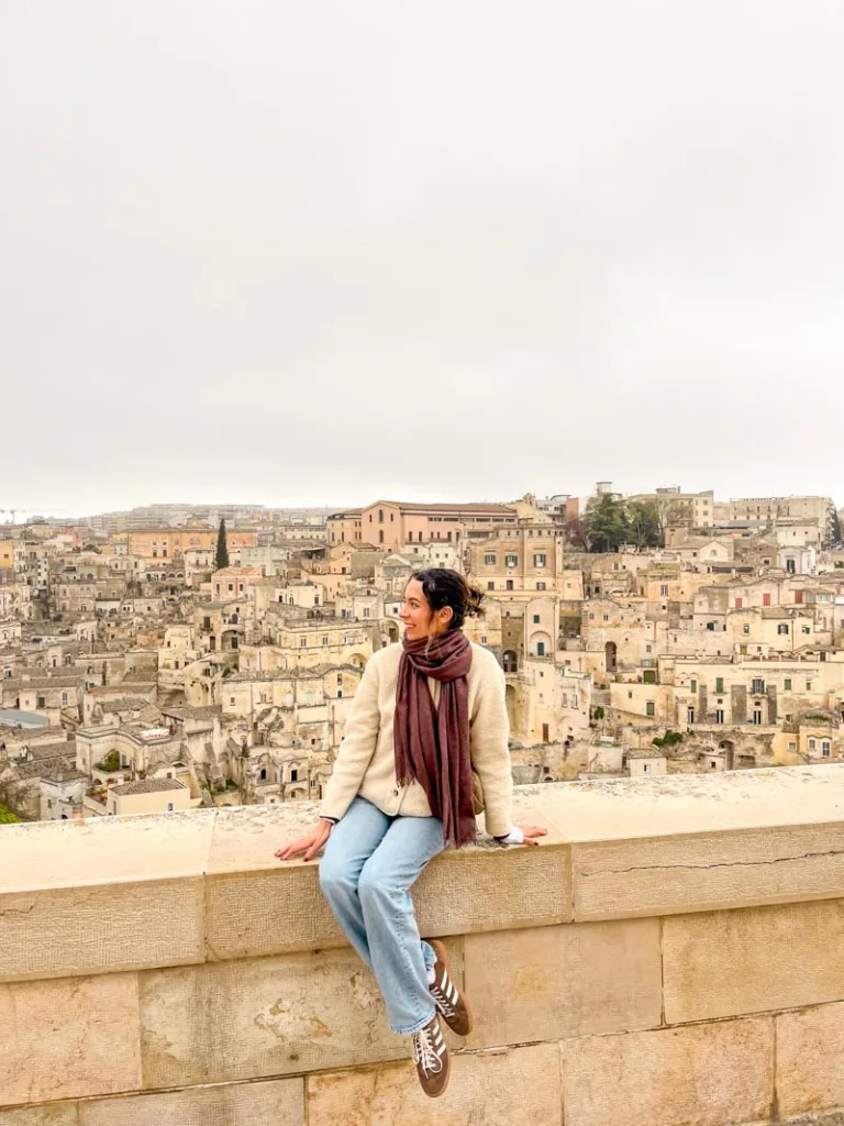 Woman sitting in front of the view point from Piazza del Duomo in Matera, Italy