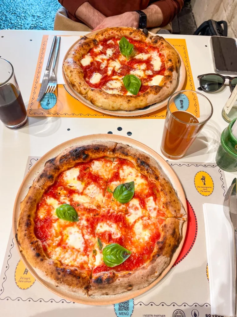 Two pizzas margheritas on a table at Piu Sud in Matera, Italy