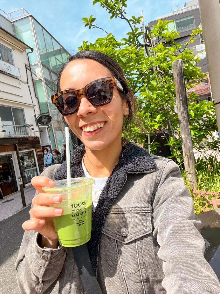 Woman holding a to-go iced matcha latte