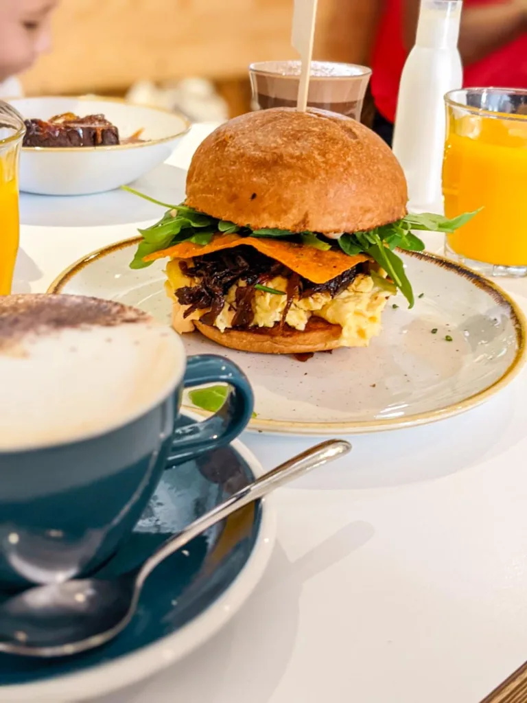 breakfast burger and a capuccino at little fern brunch restaurant in barcelona