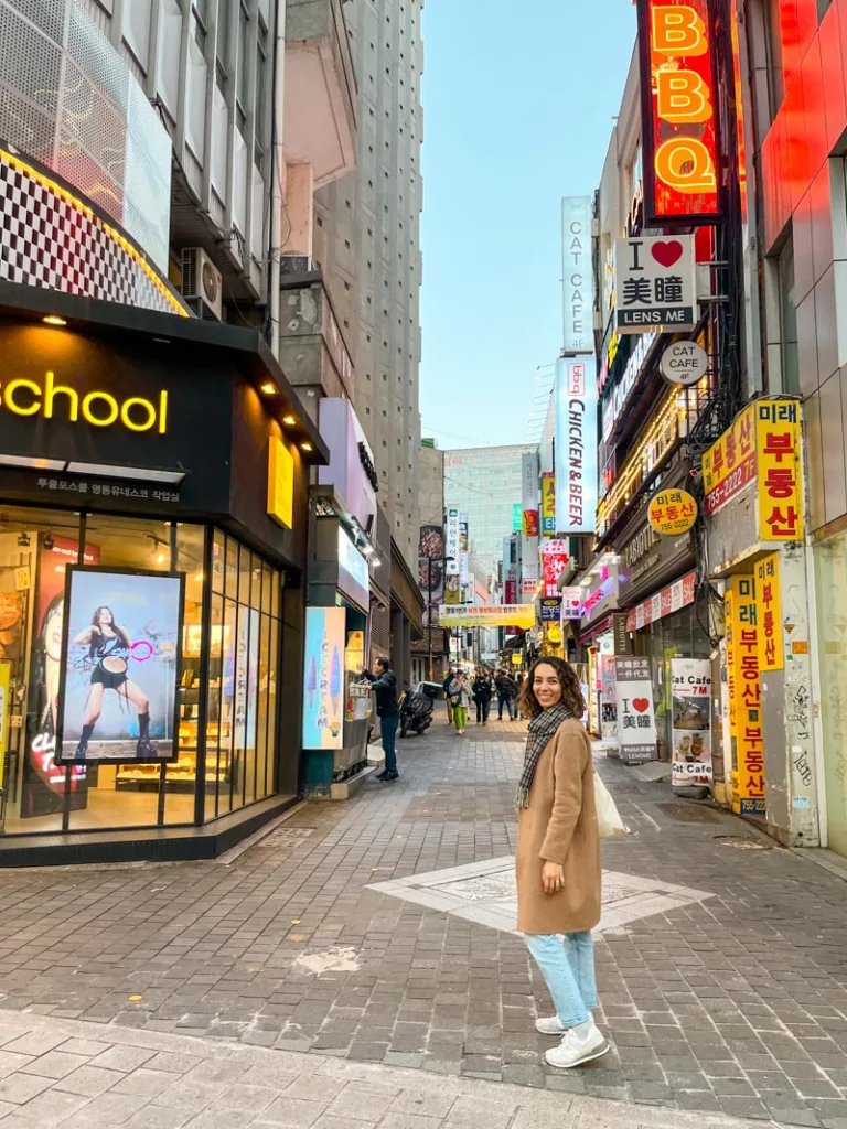 smiley woman standing in the middle of a pedestrian street in myeongdong seoul