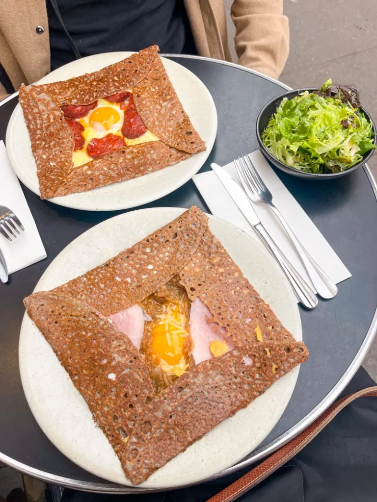 two plated crepes and a side salad at cafe breizh in paris