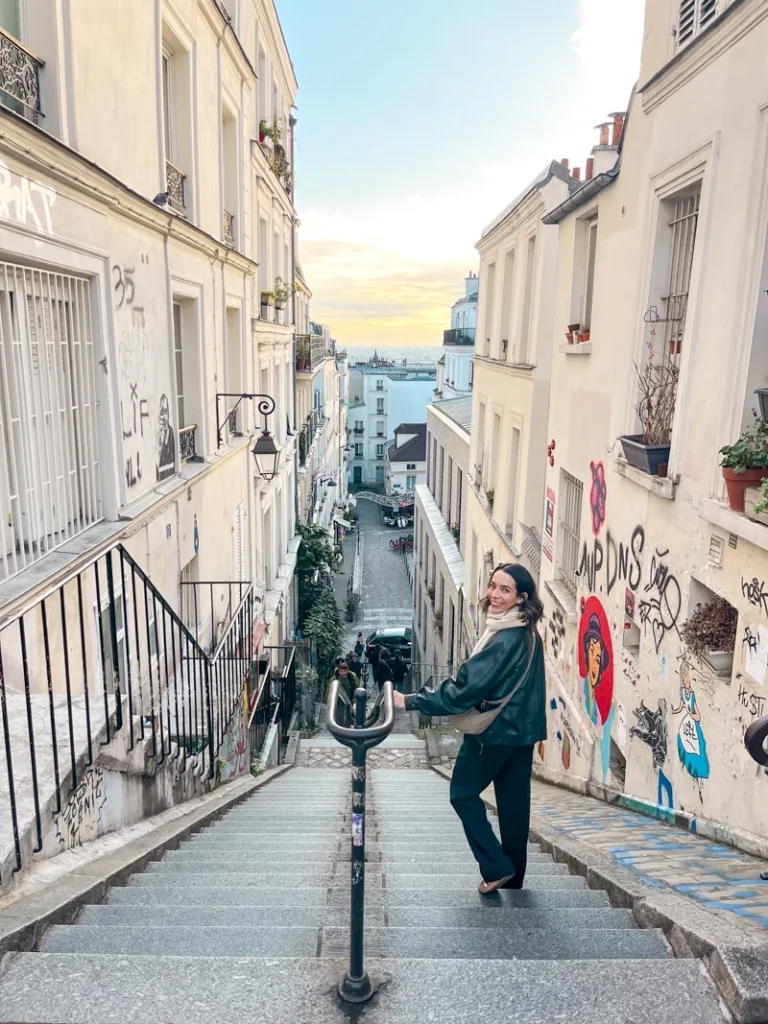 woman walking down a long staircase in the hilly streets of montmartre