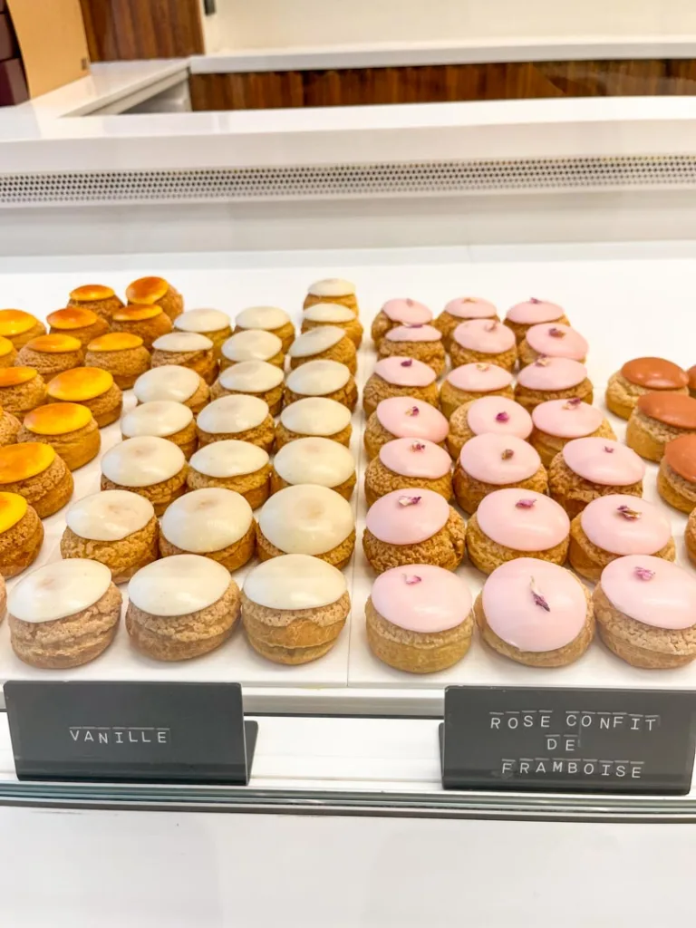 display of colorful cream puffs at popellini in paris