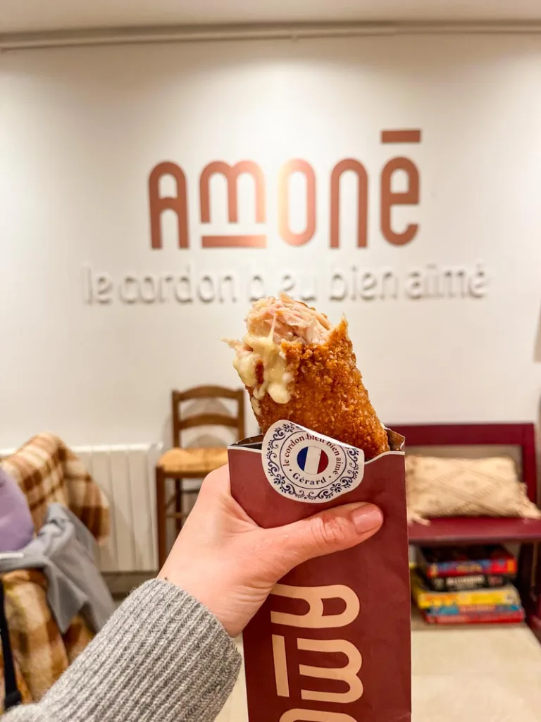 hand holding a cordon blue roll at amone restaurant in paris