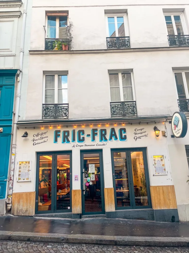 cute facade of fric frac restaurant in paris with name in blue letters