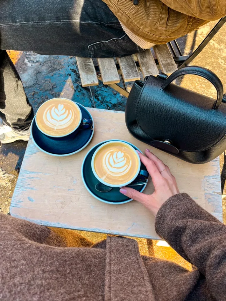 two lattes on a small outdoor table at kp cafeshop in montmartre
