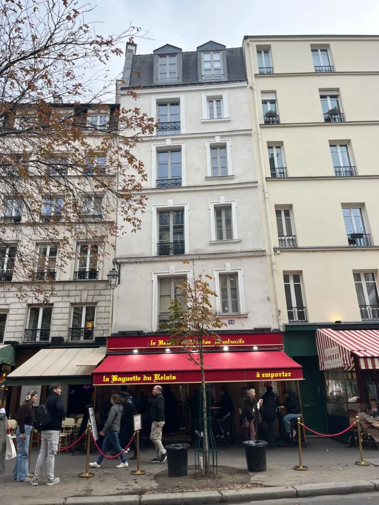 facade of la baguette du relais with a red patio cover in le marais, paris