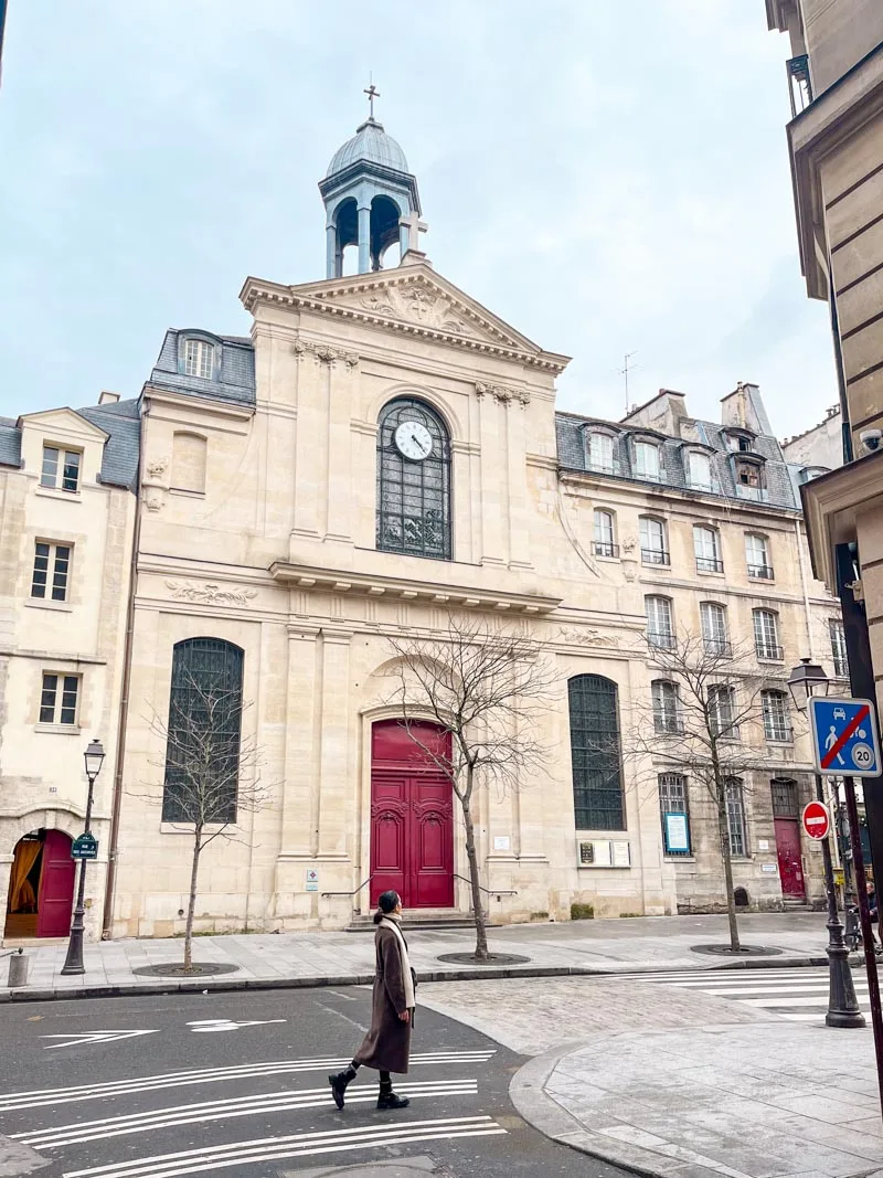 Woman walking in front of Eglise des Billettes in Le Marais in Paris