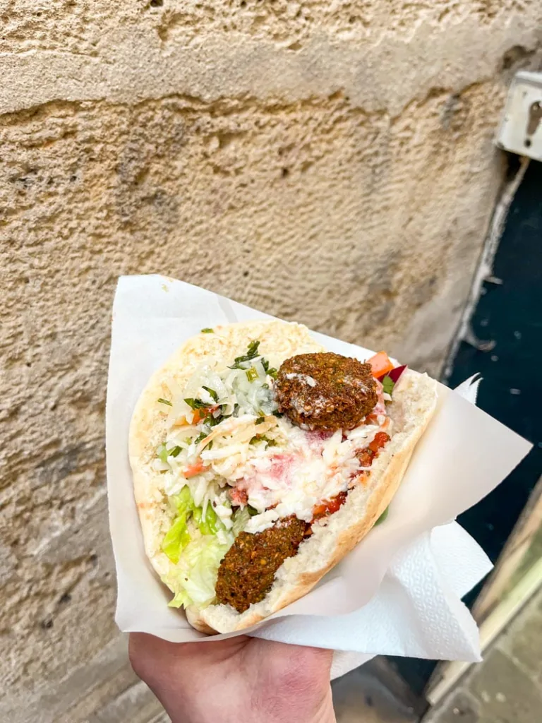 hand holding a falafel pita from maoz falafel