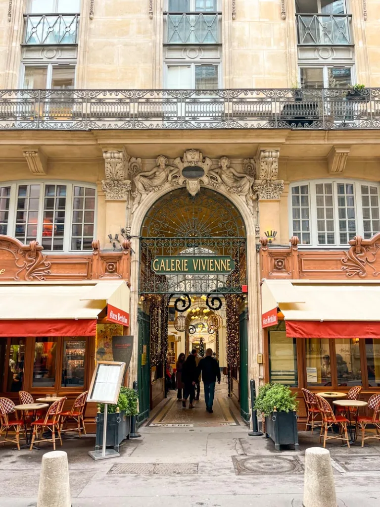 entrance to the galerie vivienne covered passage, with a name sign under an arch in paris