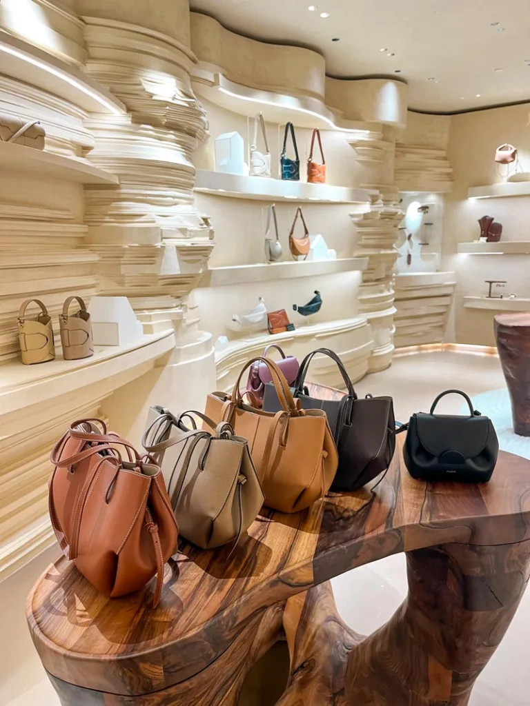 a line up of polene bags at the shop in le bon marche