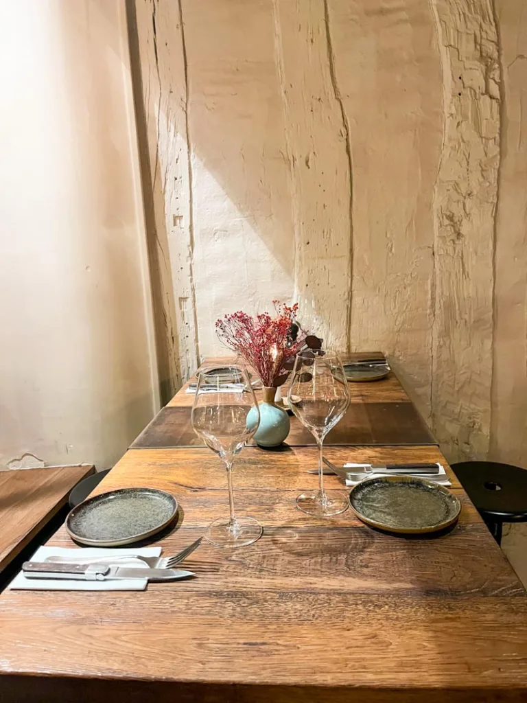 table set with plates, cutlery and wine glasses at la grande cremerie in saint germain des pres in paris