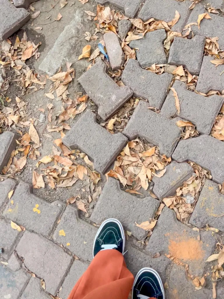 two feet stepping onto an uneven sidewalk in mexico city