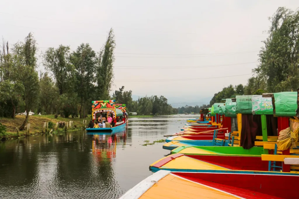 colorful trajineras lined on the water in xochimilco, mexico city