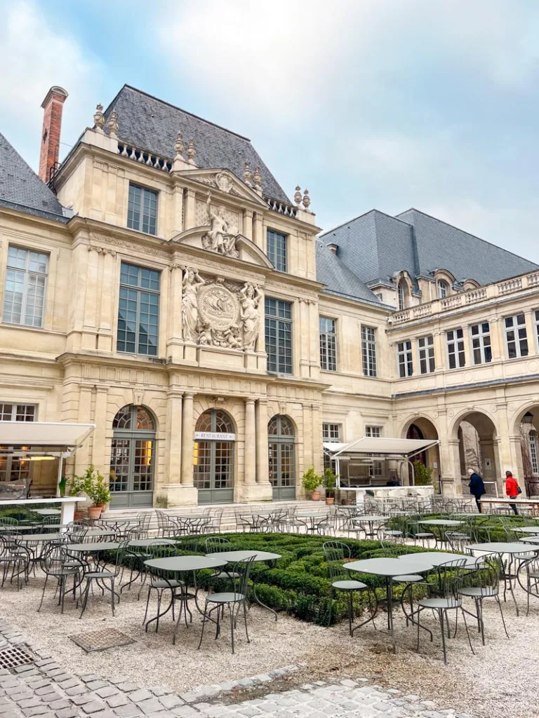 innerycourtyard with a few outdoor tables set, at the carnavalet museum in paris