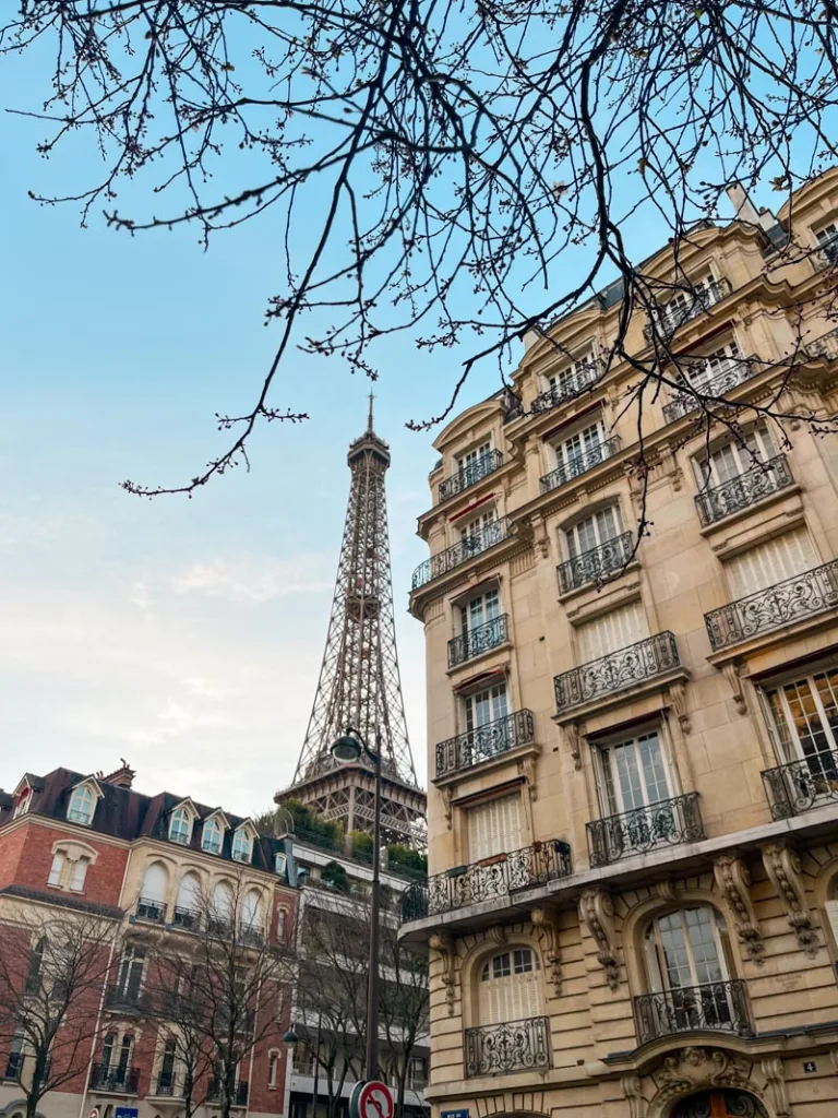 view of the eiffel tower peaking through the buildings