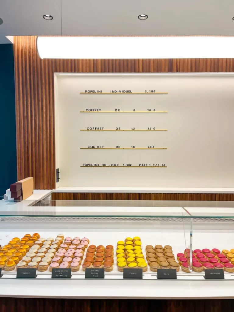 display of colorful cream puffs at popelini pastry shop in paris