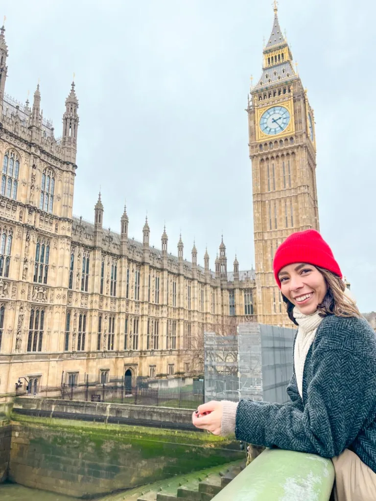 woman smiling in front of big ben and the palace of westminster in london