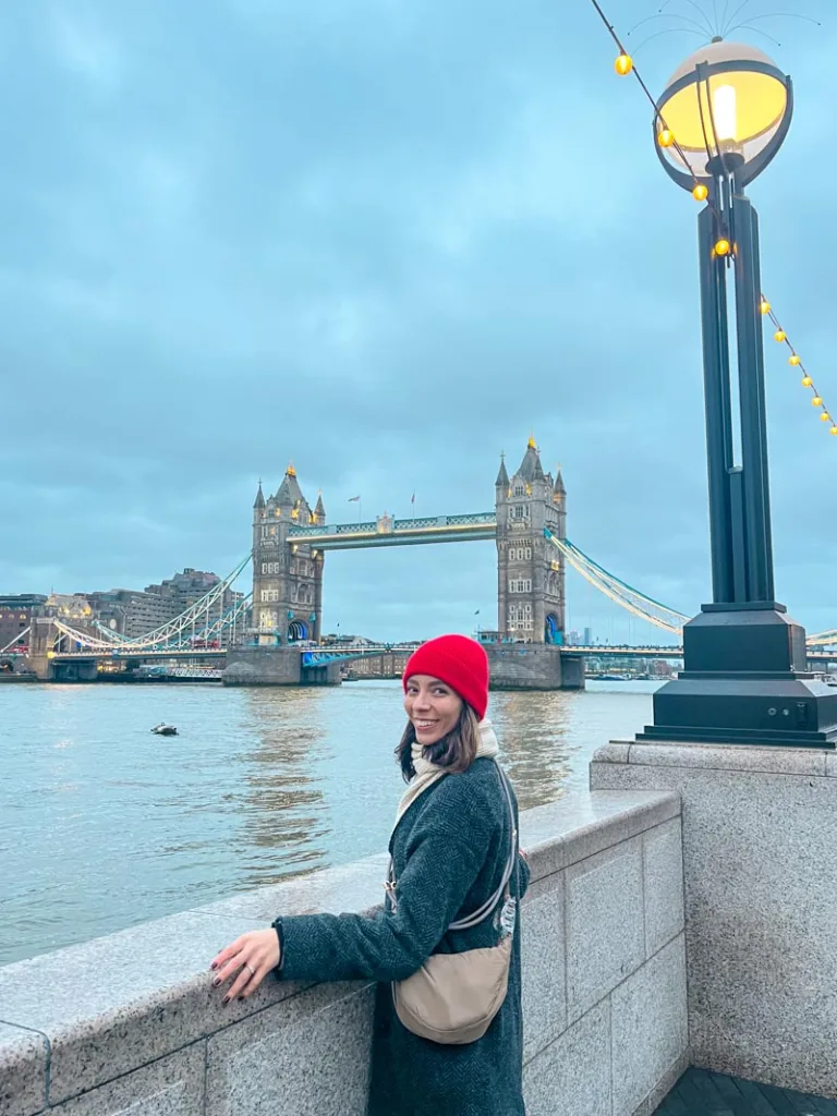 woman smiling in front of London's tower bridge