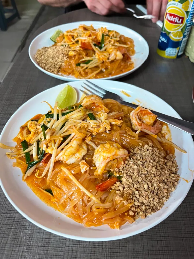 two plates with saucey shrimp pad thai at mama tam restaurant in koh tao, thailand