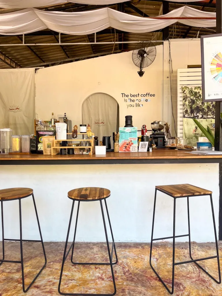 white coffee bar with wooden stools at sunrise coffee shop in koh tao, thailand
