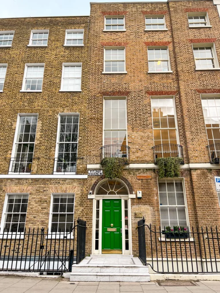cute brick building in fitzrovia with a emerald green door in london