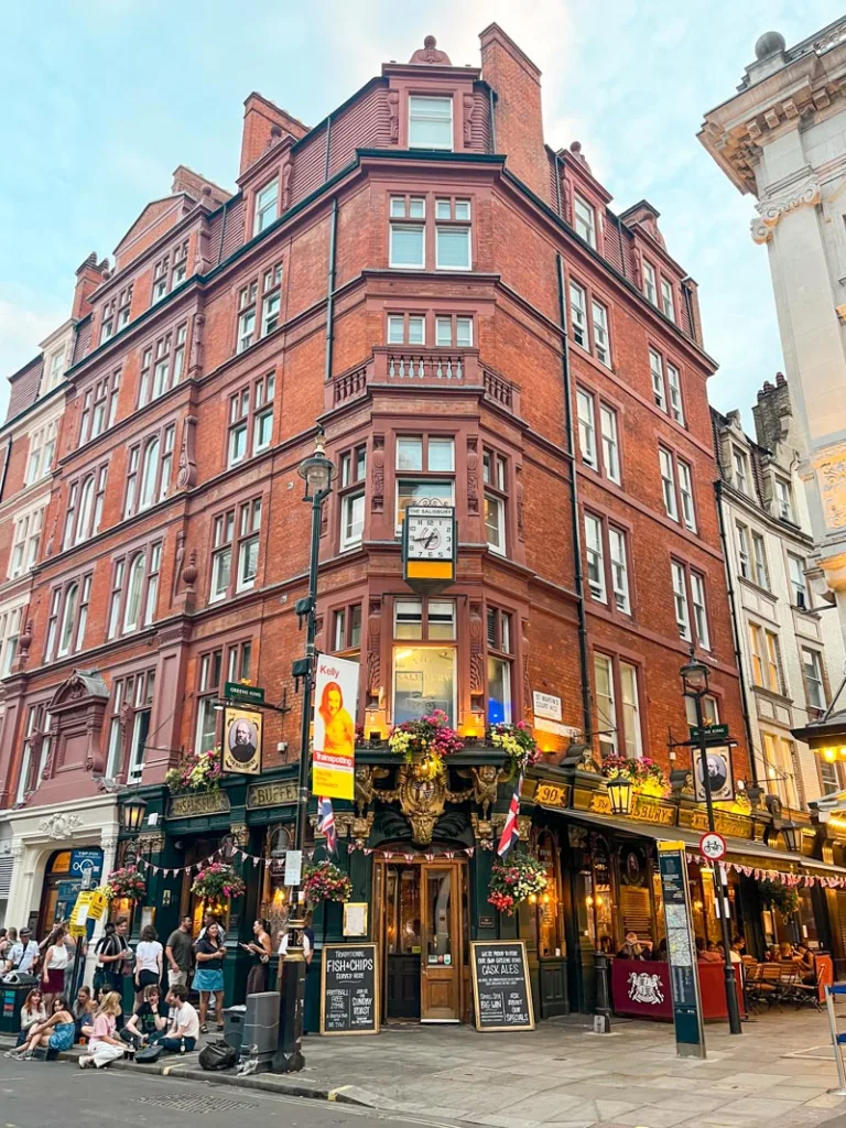 pub in a brick buildling in covent garden, london with people drinking outside