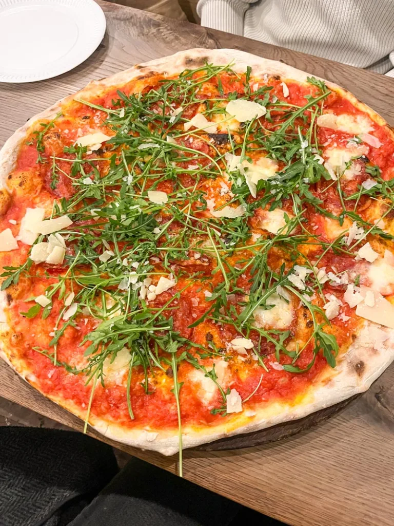 massive pizza with rucula on top at homeslice pizza in london